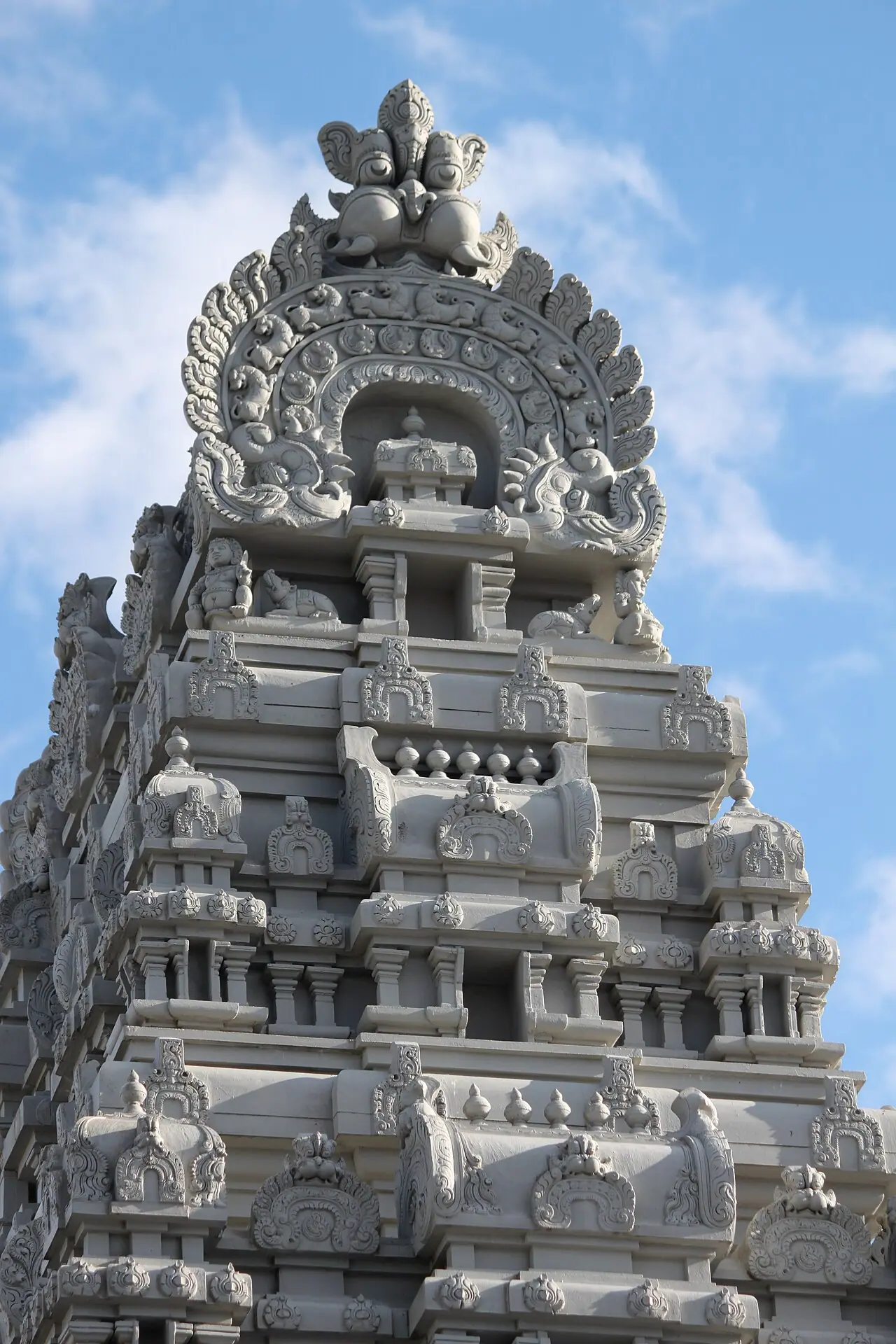 नीले आकाश के सामने क्वीन्स के फ्लशिंग में बाउन स्ट्रीट पर स्थित हिंदू टेम्पल सोसाइटी ऑफ़ नॉर्थ अमेरिका के गणेश मंदिर का नक्काशीदार गोपुरम
