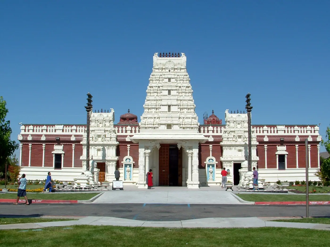 लिवरमोर, कैलिफ़ोर्निया के शिव-विष्णु मंदिर का अग्रभाग, जिसमें प्रवेश द्वार के ऊपर सफ़ेद गोपुरम और दोनों ओर लाल ईंटों का सभागार दिखता है