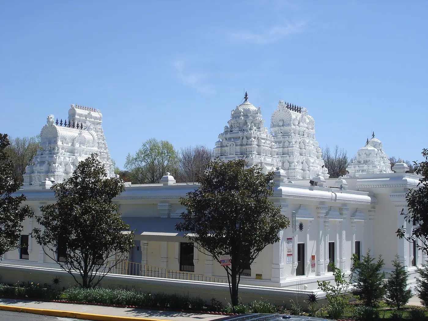 नीले आकाश के नीचे लैनहैम, मेरीलैंड में श्री शिव विष्णु मंदिर के श्वेत गोपुरम और बाहरी दीवारें