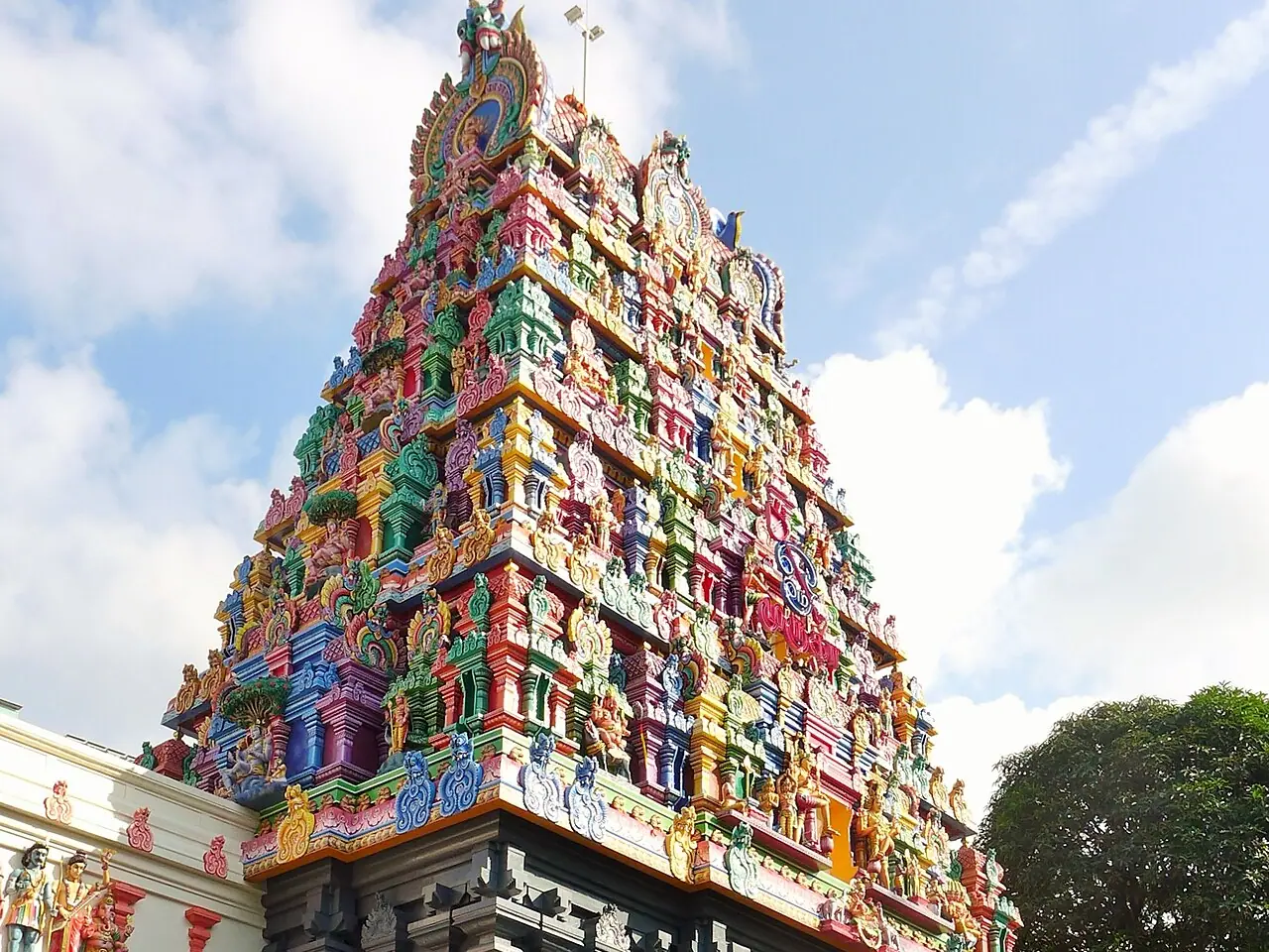 सिंगापुर के टैंक रोड स्थित श्री थेंदायुथपाणि मंदिर का रंग-बिरंगा दक्षिण भारतीय गोपुरम, जिसका आधार स्लेटी पत्थर का है; प्रवेश द्वार पर जूते रखने के रैक और सीढ़ियाँ दिखती हैं